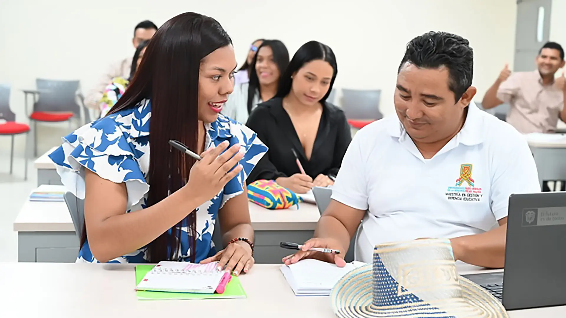 Un joven y una mujer estudiando juntos en un salón de clases.