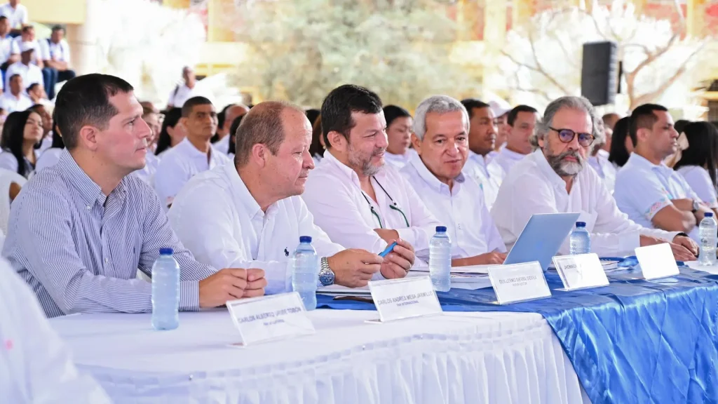 Cinco adultos en una mesa atendiendo una intervencion
