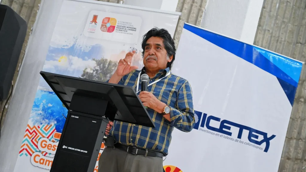 Hombre mayor habla por un micrófono en un auditorio.