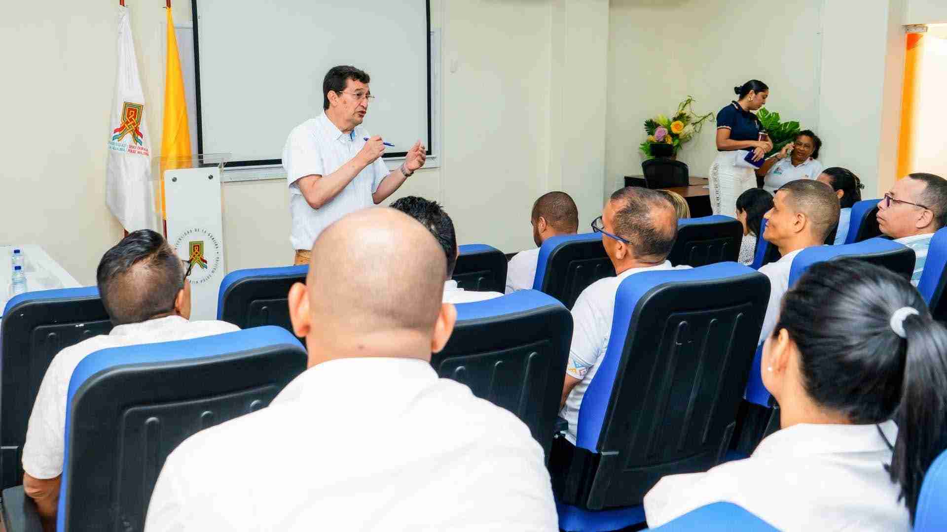 Auditorio con varias personas sentadas atendiendo un discurso dictado por un conferencista