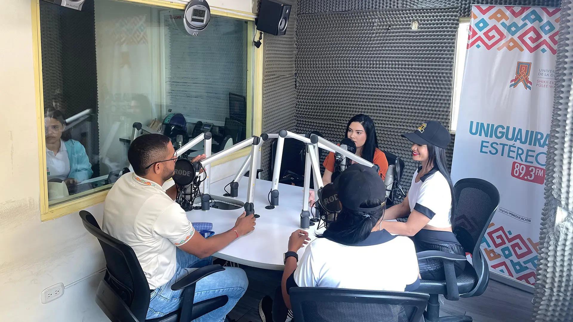 Tres mujeres y un hombre en una cabina de radio