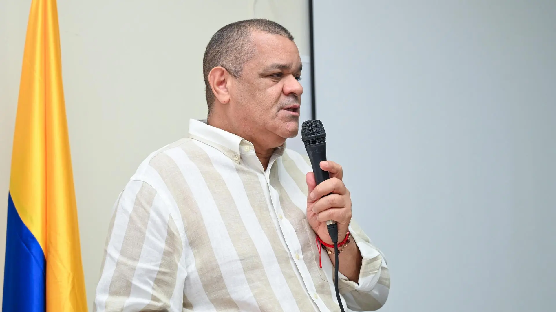 Hombre adulto con un microfono hablando 