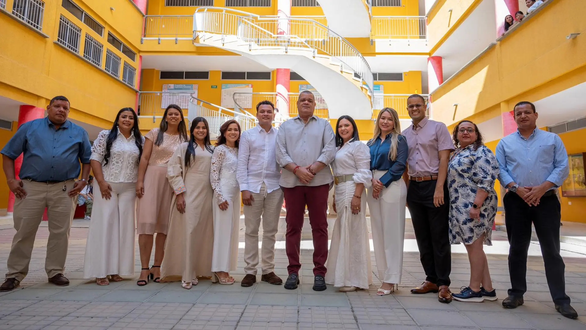 Grupo amplio de personas conformados por hombres y mujeres posando en un espacio abierto.