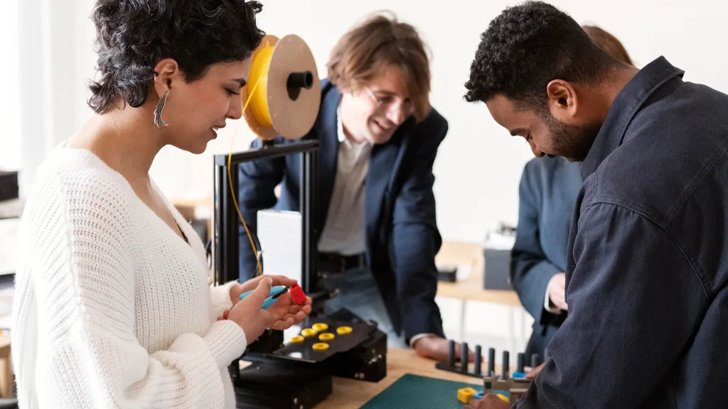 Un grupo de estudiantes colaborando en un proyecto con una impresora 3D.