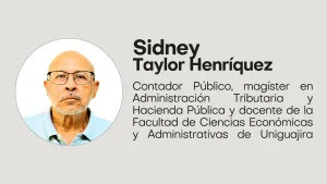 Sidney Taylor Henriquez Hombre mayor con gafas y barba canosa, vistiendo una camisa tipo polo gris claro, mirando de frente.