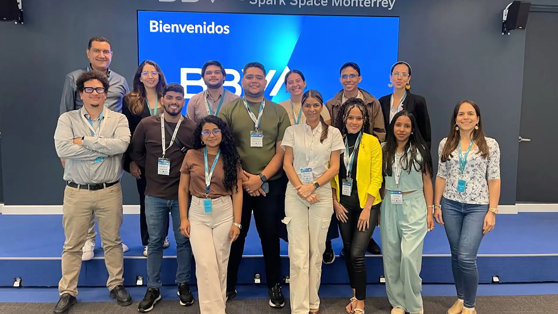 Grupo de estudiantes y profesionales posan en un auditorio corporativo frente a una pantalla con el mensaje “Bienvenidos – BBVA Spark Space Monterrey”, durante una visita académica.