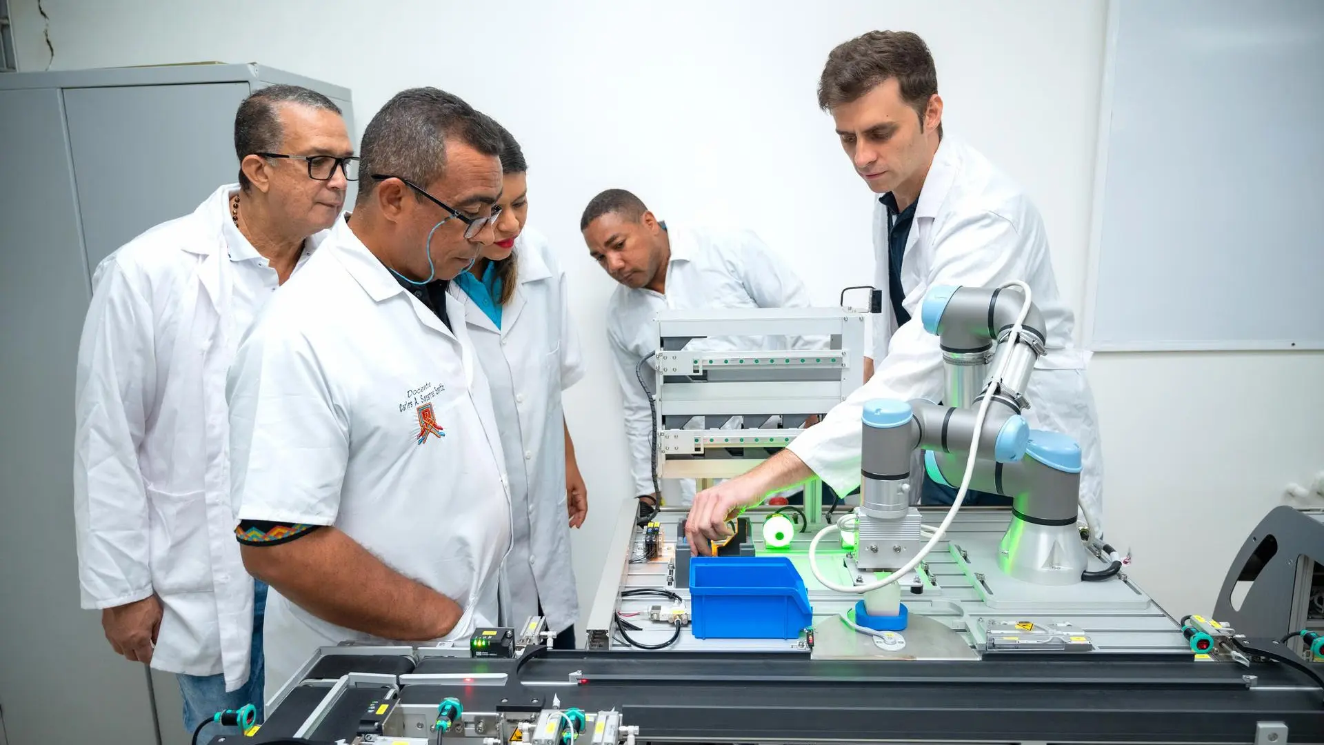Un grupo de docentes de la Universidad de La Guajira observa una demostración práctica del sistema automatizado SIF-400 durante una sesión de capacitación en laboratorio, guiada por un instructor.