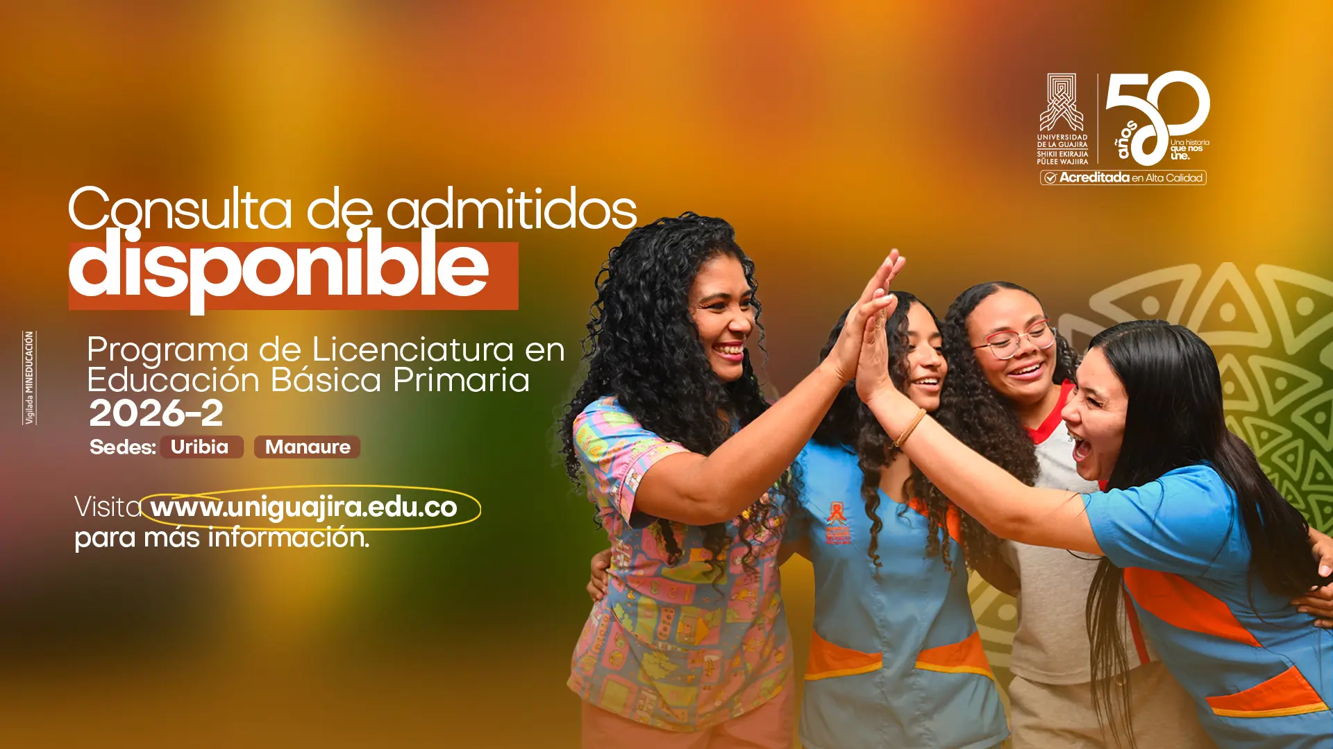 Imagen promocional de la Universidad de La Guajira con fondo degradado en tonos dorados y naranja. En el lado izquierdo se lee el mensaje principal: "Consulta de admitidos disponible", seguido de la información del Programa de Licenciatura en Educación Básica Primaria 2026-2, sedes Uribia y Manaure, con el enlace www.uniguajira.edu.co. En la esquina superior derecha aparece el logo institucional junto al emblema de los 50 años de la universidad y el sello de Acreditada en Alta Calidad. En el centro y lado derecho de la imagen, cuatro jóvenes mujeres sonrientes celebran chocando las manos, transmitiendo alegría y entusiasmo. Visten ropa colorida en tonos azul, naranja y gris. Al fondo derecho se aprecia un motivo decorativo indígena wayuu en color verde claro.