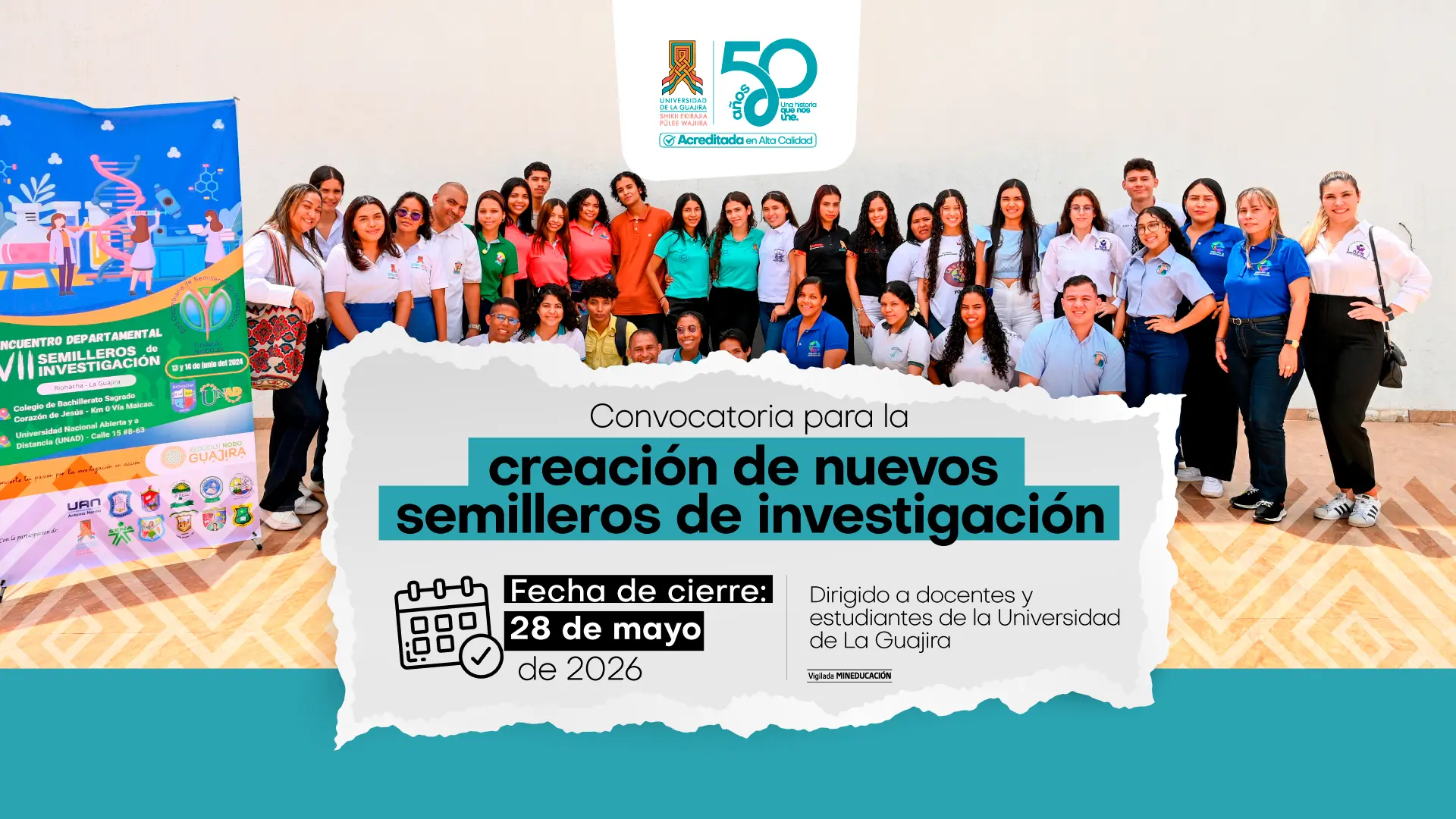 Grupo de estudiantes y docentes de la Universidad de La Guajira posando para una foto en un espacio académico. En la parte inferior se lee: “Convocatoria para la creación de nuevos semilleros de investigación”. Incluye la fecha de cierre: 28 de mayo de 2026, y está dirigido a docentes y estudiantes. En la parte superior aparece el logo de los 50 años de la universidad. A la izquierda hay un banner relacionado con un encuentro de semilleros de investigación.
