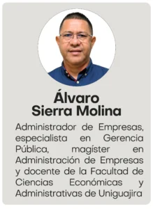 La transformación de la Universidad de La Guajira de la mano de un líder positivo2026 Retrato de medio cuerpo de un hombre de cabello corto y gafas, vistiendo una camisa azul oscuro con pequeños detalles y cuello con vivos rojos, posando sobre un fondo blanco continuo.