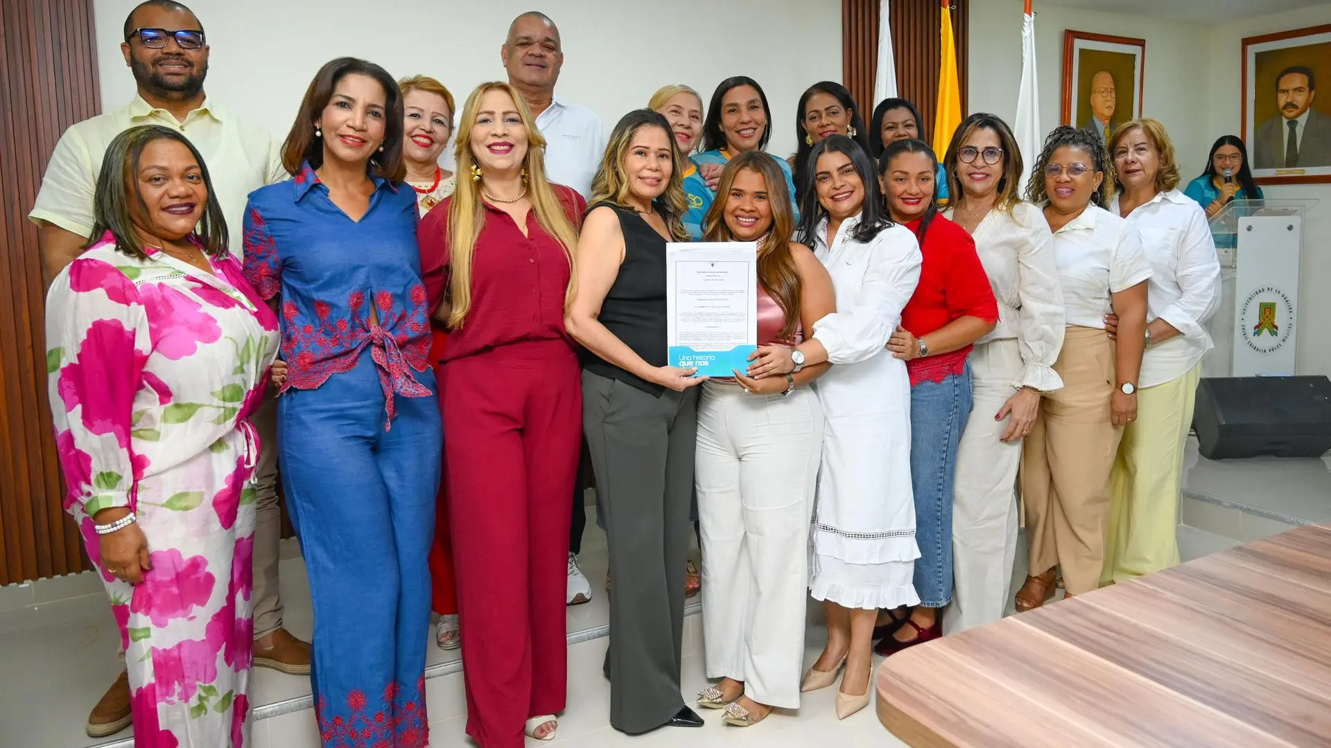 Docentes y funcionarios del programa de Trabajo Social posan sonrientes en grupo, sosteniendo la resolución de Acreditación en Alta Calidad.