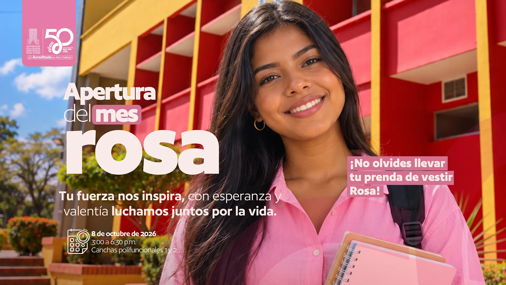 Pieza gráfica de la Apertura del Mes Rosa de la Universidad de La Guajira. En la imagen aparece una estudiante sonriente, vestida con una camisa rosa y llevando una mochila y varios cuadernos, frente a una de las instalaciones de la Universidad. Sobre la imagen se lee “Apertura del mes rosa” y el mensaje “Tu fuerza nos inspira, con esperanza y valentía luchamos juntos por la vida”. También se invita a llevar una prenda de vestir rosa. La actividad se realizará el 8 de octubre de 2026, de 3:00 a 6:30 p. m., en las canchas polifuncionales 1 y 2.
