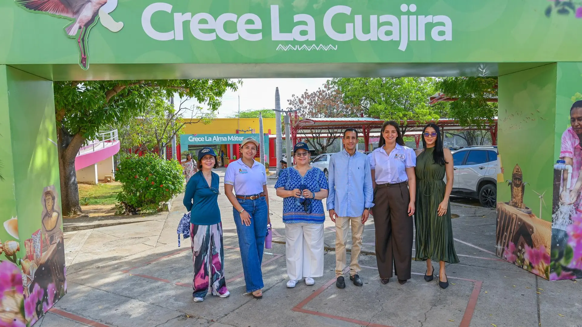 Equipo de trabajo posa frente al arco de bienvenida “Crece La Guajira”, en un espacio al aire libre rodeado de vegetación y elementos alusivos a la identidad cultural y natural del departamento de La Guajira.