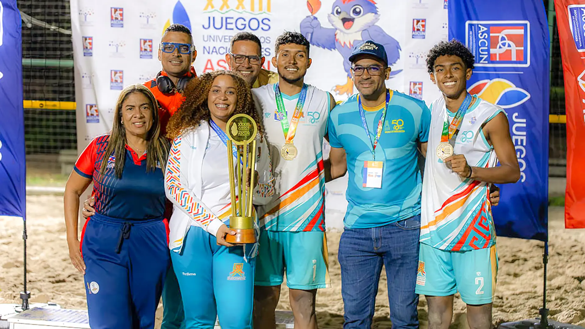 Delegación de Uniguajira posa con el trofeo de campeones de voleibol playa en los XXXIII Juegos Nacionales Universitarios ASCUN.