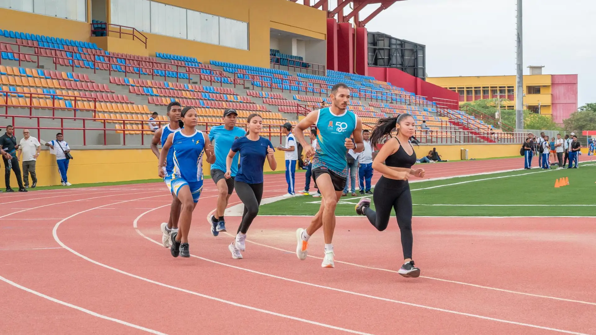 Deportistas participan en una jornada de atletismo en la pista del escenario deportivo de la Universidad de La Guajira, promoviendo la actividad física, el bienestar y la integración de la comunidad universitaria en el marco de la conmemoración de los 50 años de la institución.